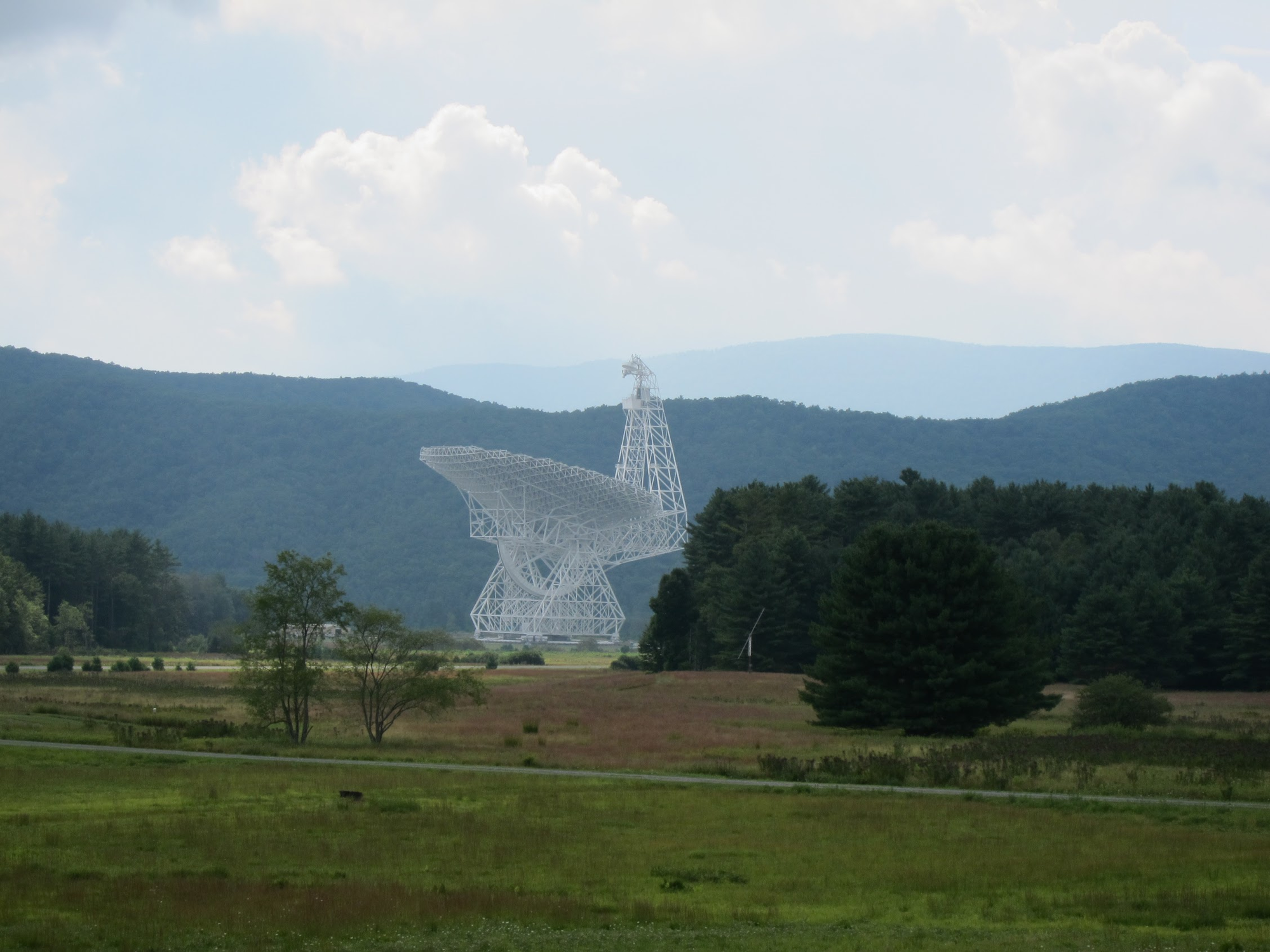 The Green Bank Telescope rising above the West Virginia hills, its massive white dish structure visible from over a mile away