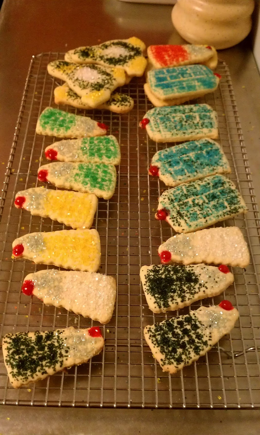 Finished batch of Tardis, Tux, and Dalek cookies cooling on a wire rack
