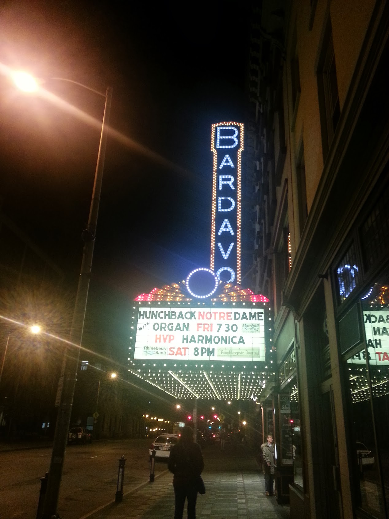 The Bardavon Theatre marquee at night showing "Hunchback Notre Dame with Organ Fri 7:30" — the illuminated BARDAVO sign glowing blue above the marquee on a dark Poughkeepsie street